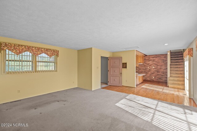 carpeted empty room featuring a textured ceiling