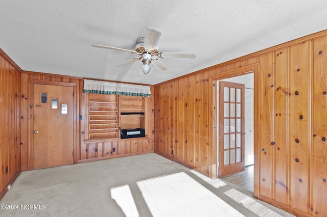 living room featuring light carpet, ornamental molding, and wooden walls