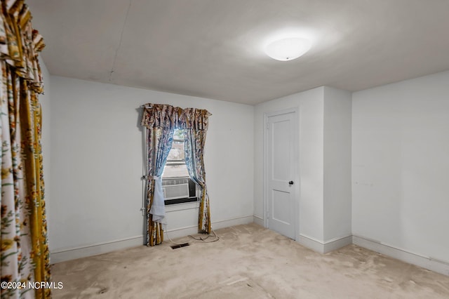 spare room with cooling unit and light carpet