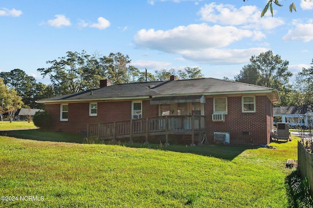 back of house featuring a deck and a lawn