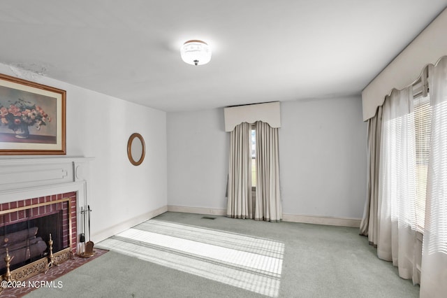 unfurnished living room with light carpet and a brick fireplace