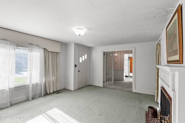 unfurnished living room featuring a fireplace and light colored carpet