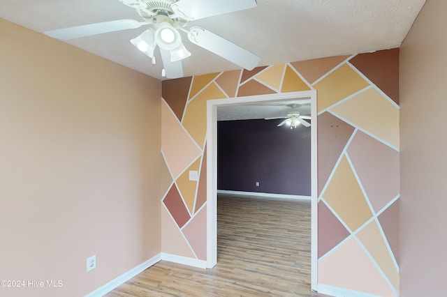 spare room featuring ceiling fan, a textured ceiling, and light hardwood / wood-style flooring