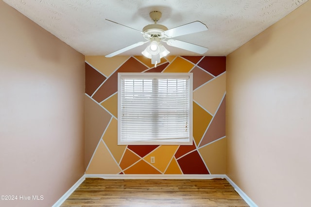 miscellaneous room featuring a textured ceiling, lofted ceiling, hardwood / wood-style flooring, and ceiling fan