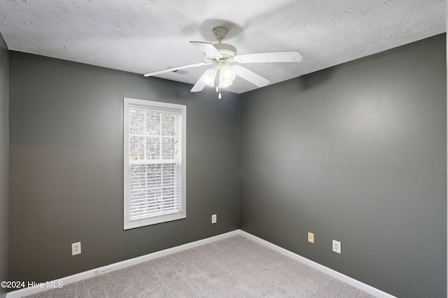 carpeted empty room with a textured ceiling and ceiling fan