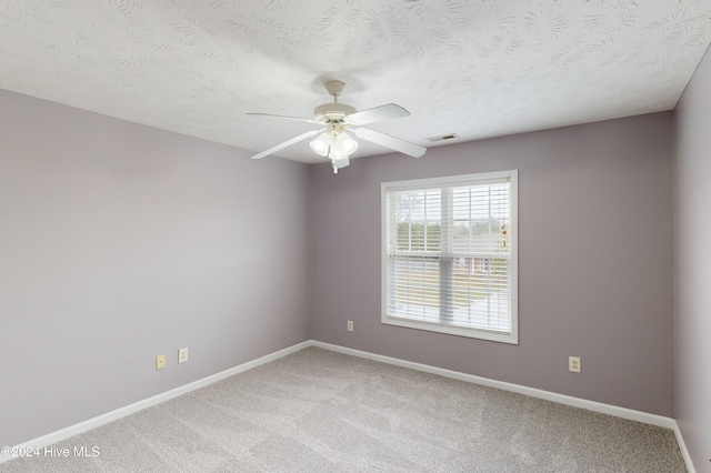 empty room featuring ceiling fan, a textured ceiling, and carpet floors