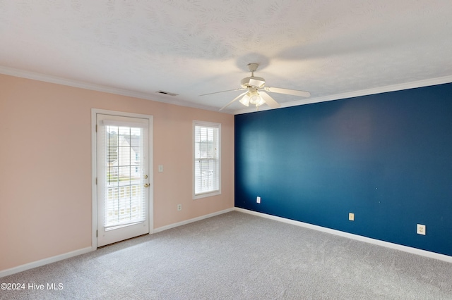 carpeted spare room featuring ceiling fan, a textured ceiling, and crown molding