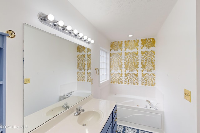 bathroom with a washtub, vanity, and a textured ceiling