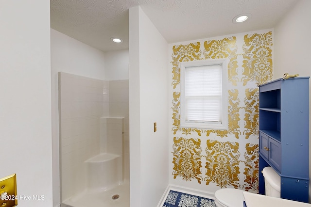 bathroom with toilet, a textured ceiling, and walk in shower