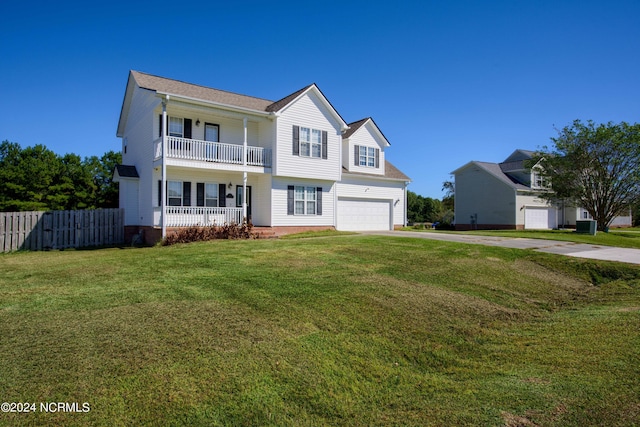 view of front facade with a front lawn, a balcony, and a garage