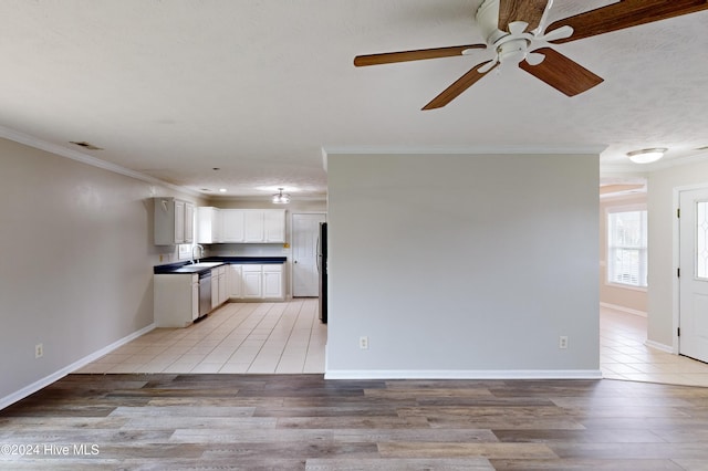 unfurnished living room featuring ornamental molding, light wood-type flooring, ceiling fan, and sink