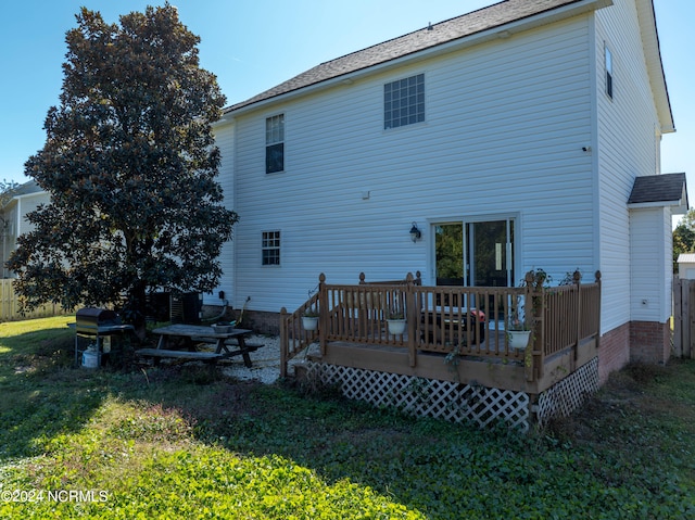 rear view of property featuring a yard and a deck