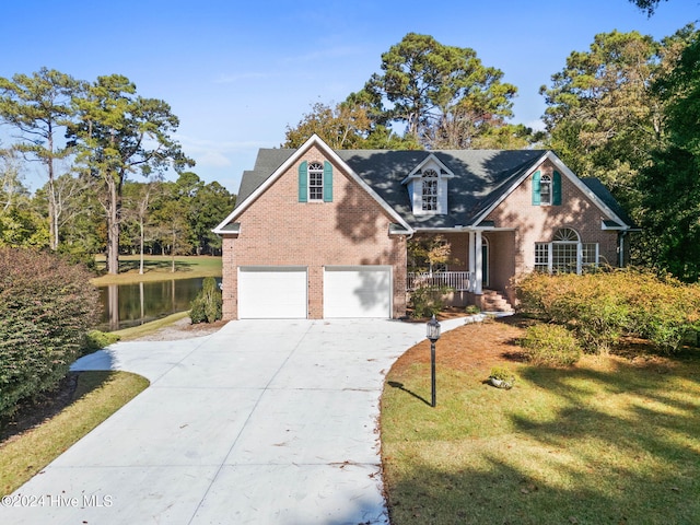 view of front of house featuring a garage, a porch, a water view, and a front yard