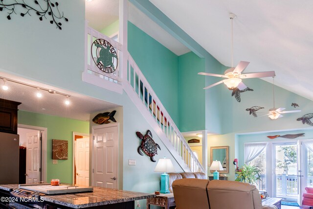 living room with rail lighting, ceiling fan, and high vaulted ceiling