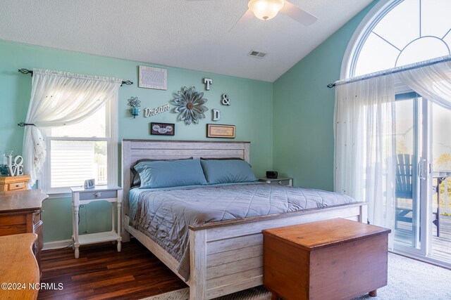 bedroom featuring access to exterior, dark hardwood / wood-style floors, vaulted ceiling, a textured ceiling, and ceiling fan