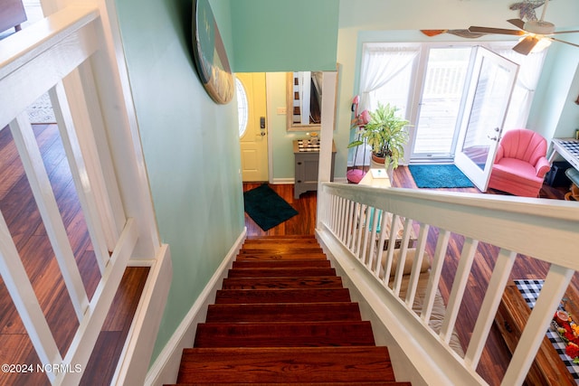 stairs with hardwood / wood-style flooring and ceiling fan