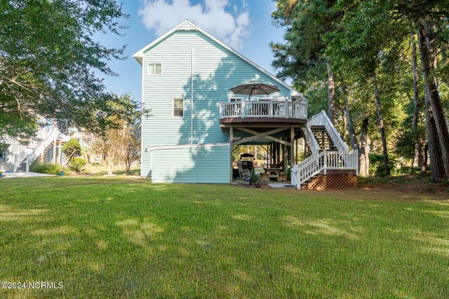 rear view of house with a yard and a deck