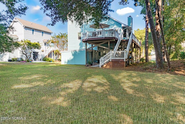 back of house with a wooden deck and a lawn