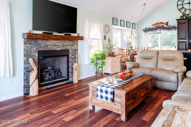 living room with vaulted ceiling, a stone fireplace, and dark hardwood / wood-style floors