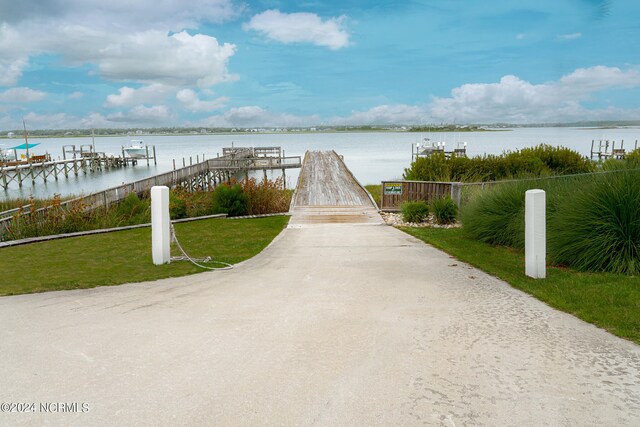 view of dock featuring a water view and a lawn