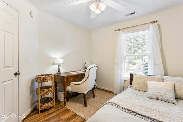 bedroom with multiple windows, hardwood / wood-style floors, and ceiling fan