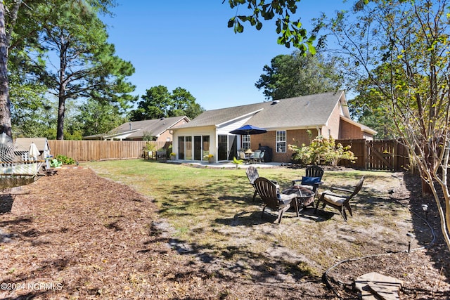 rear view of house featuring a patio area and a fire pit