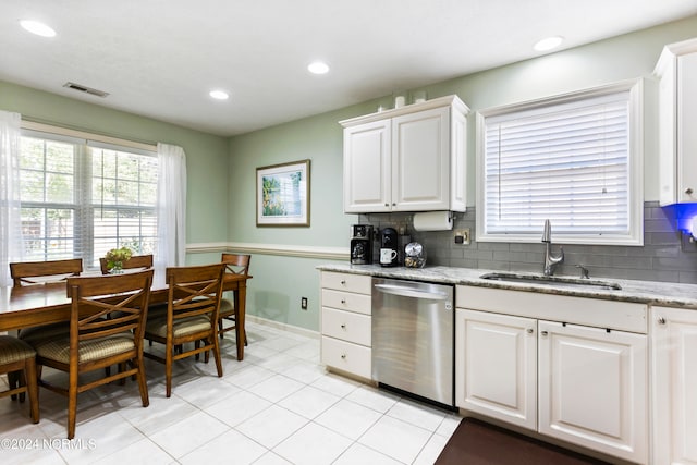 kitchen featuring stainless steel dishwasher, sink, white cabinets, and a wealth of natural light