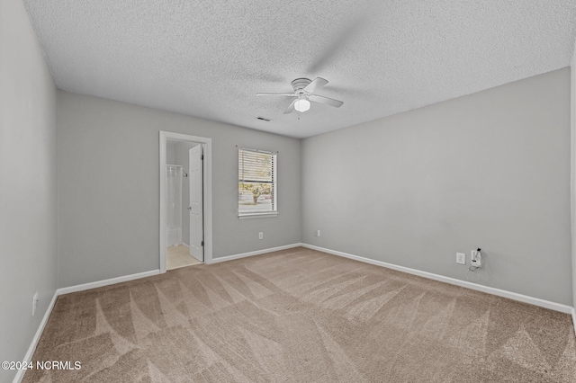 carpeted spare room featuring a textured ceiling and ceiling fan