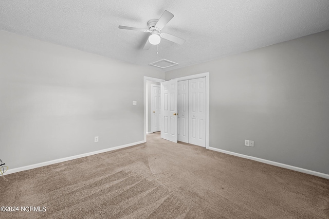 unfurnished bedroom with a textured ceiling, carpet floors, a closet, and ceiling fan