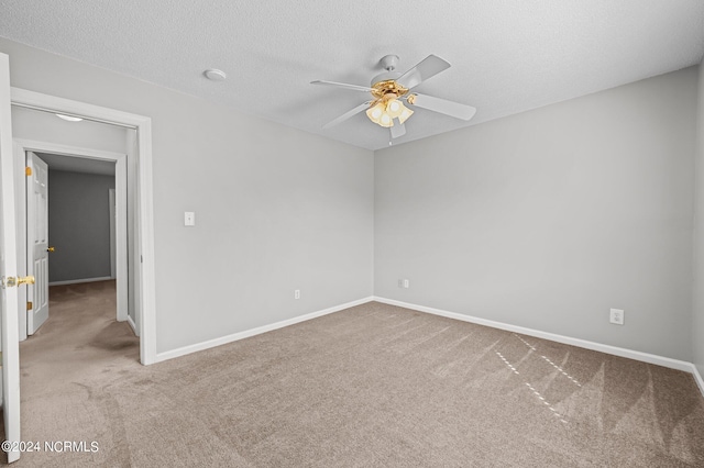 empty room featuring ceiling fan, carpet, and a textured ceiling