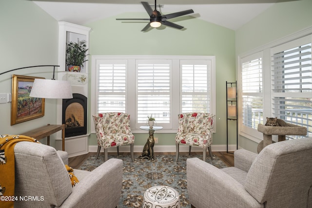 living room featuring ceiling fan, lofted ceiling, wood finished floors, healthy amount of natural light, and baseboards