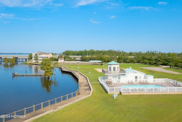 aerial view of property and surrounding area featuring a nearby body of water and a pool