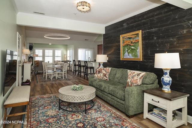 living area with crown molding and wood finished floors