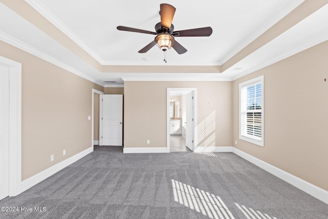 interior space featuring ornamental molding, ceiling fan, a raised ceiling, and carpet floors