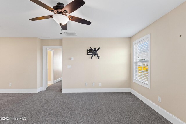 46 Covey Ct, Hampstead, NC 28443 - empty room with visible vents, a ceiling fan, baseboards, and dark carpet