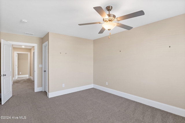 carpeted spare room featuring ceiling fan