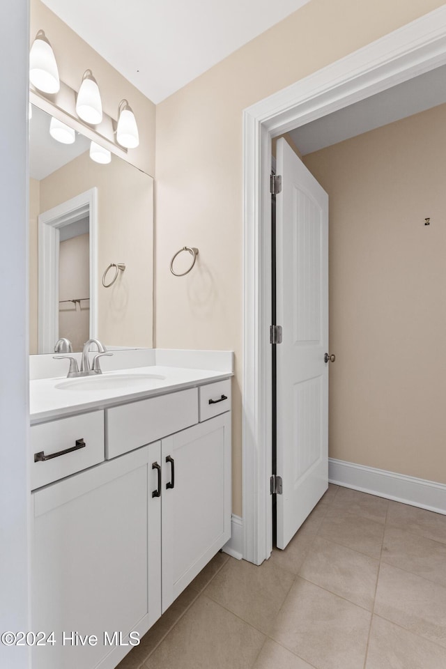 bathroom featuring tile patterned floors, baseboards, and vanity