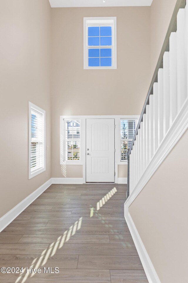 46 Covey Ct, Hampstead, NC 28443 - foyer entrance featuring baseboards, a high ceiling, stairs, and wood finished floors