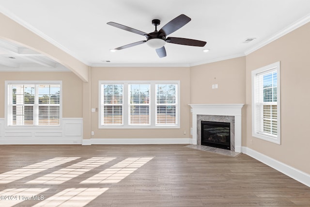 unfurnished living room featuring light hardwood / wood-style floors, crown molding, a fireplace, and ceiling fan