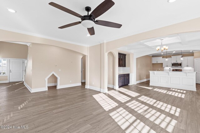 46 Covey Ct, Hampstead, NC 28443 - unfurnished living room featuring light wood finished floors, arched walkways, recessed lighting, baseboards, and ornamental molding