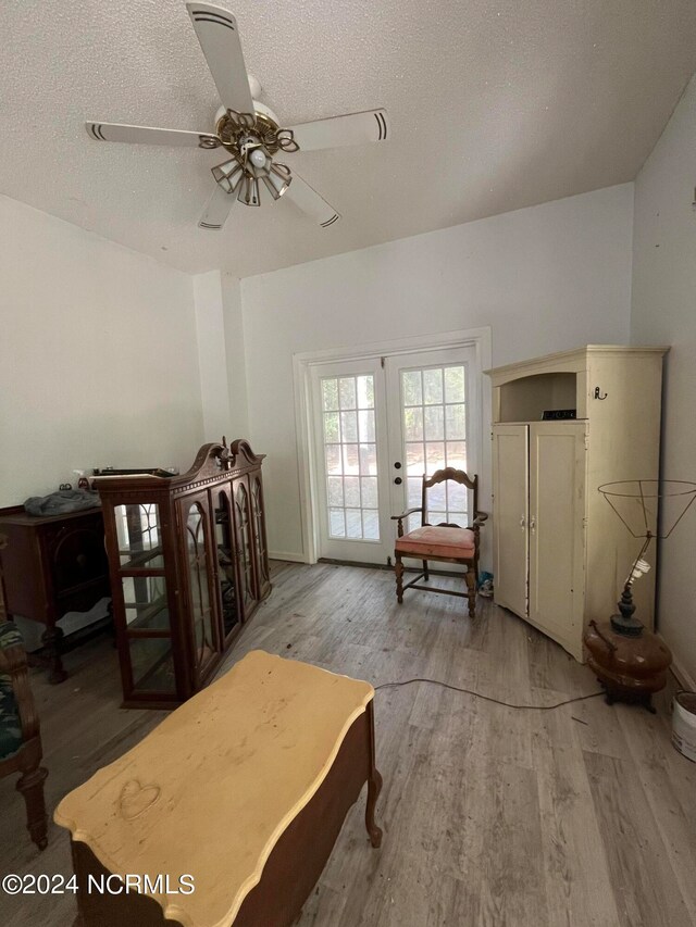 bedroom featuring french doors, a textured ceiling, hardwood / wood-style flooring, and ceiling fan