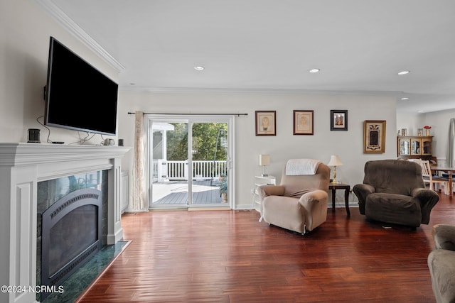 living room with crown molding, a fireplace, and hardwood / wood-style floors