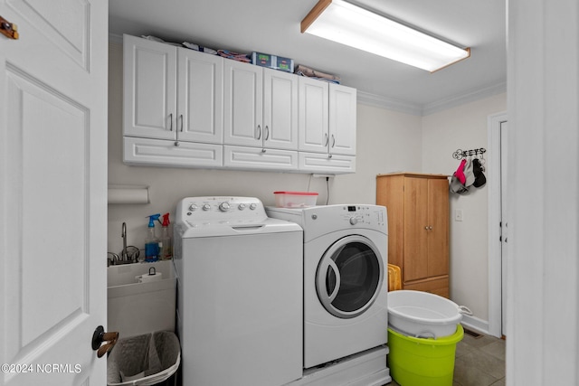 laundry room featuring washer and dryer, tile patterned floors, ornamental molding, and cabinets