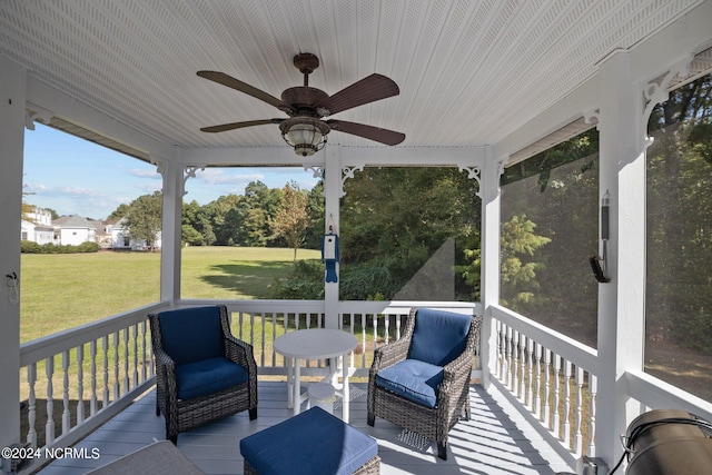 wooden deck featuring a yard and ceiling fan