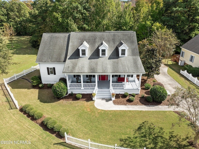 cape cod home featuring covered porch and a front lawn