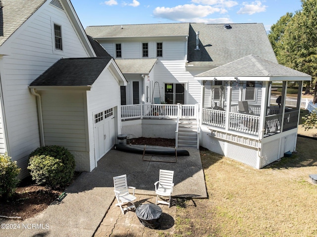 back of house with a wooden deck, a yard, and a garage