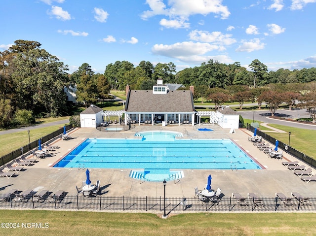 view of swimming pool with a storage shed and a patio area