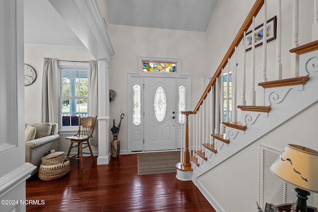 foyer entrance with dark wood-type flooring and crown molding