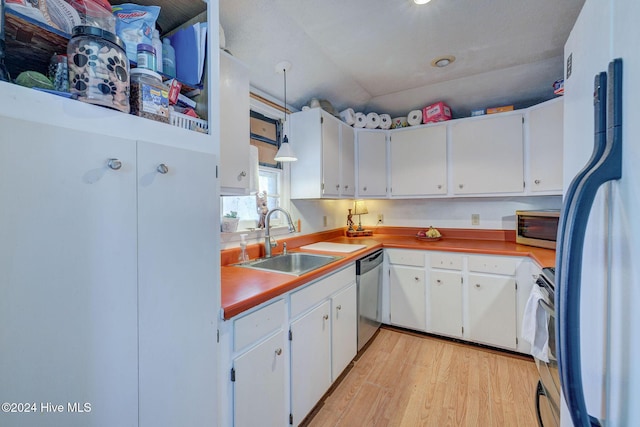 kitchen featuring appliances with stainless steel finishes, sink, white cabinets, and light wood-type flooring