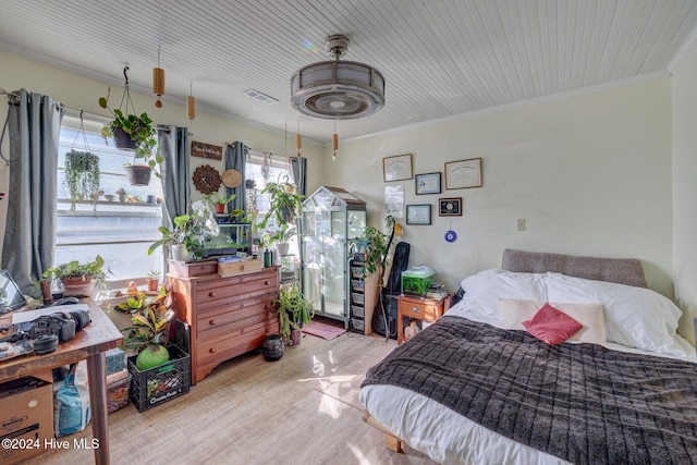 bedroom featuring crown molding and light wood-type flooring